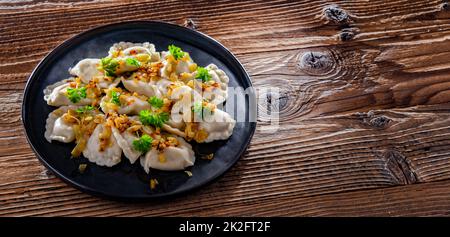 Komposition mit einem Teller klassischer Pierogien mit Zwiebeln Stockfoto