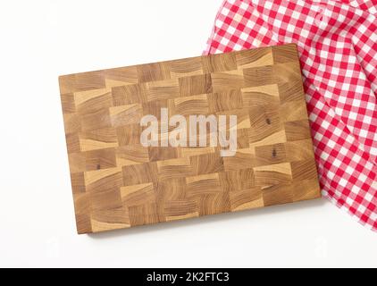 Leere rechteckige Holzküche Schneidebrett und rotes Handtuch in einem weißen Käfig auf einem weißen Tisch, Draufsicht Stockfoto