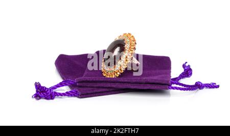 Geschweißtes Heizruby mit smaragdgelbem und gelbem Saphir Schmuckstück oder Edelsteinen Ring auf violettem Samtbeutel. Sammlung von Accessoires für natürliche Edelsteine. Studioaufnahme Stockfoto