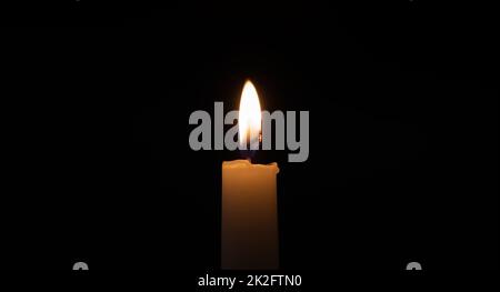 Brennende Kerze in der Dunkelheit Stockfoto