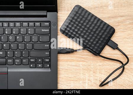 Eine tragbare festplatte, die mit einem Laptop verbunden ist Stockfoto