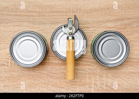 Alter Dosenöffner und Metalldosen auf dem Tisch Stockfoto