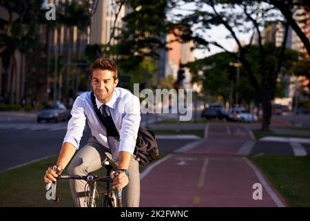 Keine Mitgliedschaft im Fitnessstudio erforderlich. Aufnahme eines Geschäftsmannes, der mit seinem Fahrrad zur Arbeit pendelt. Stockfoto