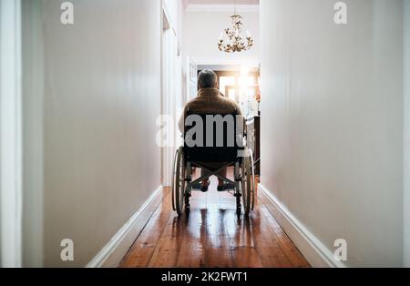 Lass dich vom Versprechen von morgen in Gang halten. Rückansicht einer älteren Frau, die zu Hause in ihrem Rollstuhl sitzt. Stockfoto