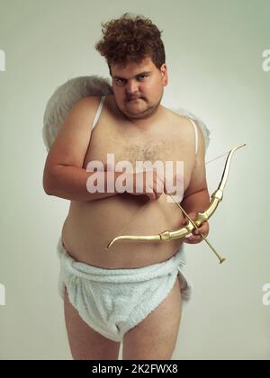 Hes bringt die Liebe dieses Valentines. Ein übergewichtiger Mann, der als Cherub gekleidet war, während er isoliert war. Stockfoto