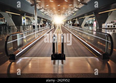 Ihr Flug ist so. Ausgeschnittene Aufnahme eines sich bewegenden Laufwegs im Flughafen. Stockfoto