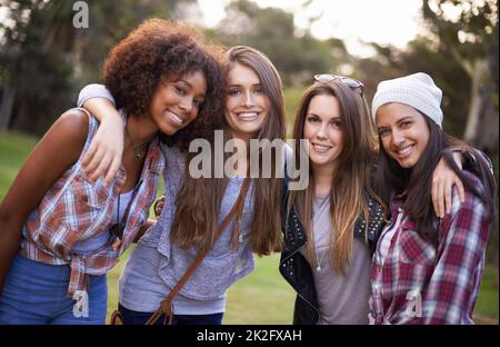 Die besten Freunde hängen im Park herum. Eine kurze Aufnahme einer Gruppe junger Frauen, die gemeinsam die Natur genießen. Stockfoto