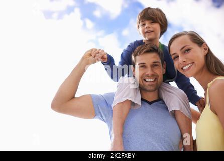 Das Beste aus dem Urlaub machen. Porträt eines glücklichen Paares mit ihrem Sohn im Freien. Stockfoto