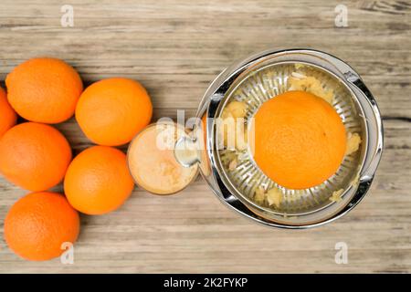 Draufsicht auf eine Orange beim Entsaften mit einem elektrischen Zitruspresse Stockfoto