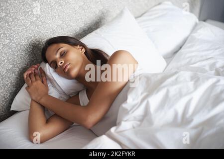 Friedlich schlafen. Eine schöne junge Frau, die in ihrem Bett schläft. Stockfoto