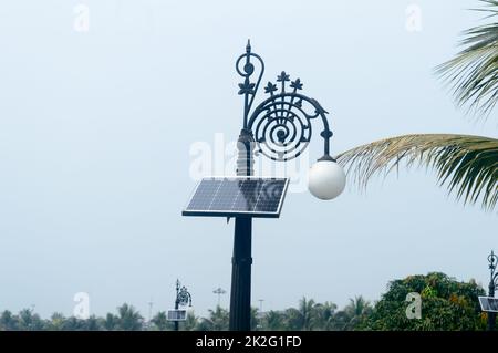 Klassisches ästhetisches dekoratives Solar LED-Lampenlicht vor blauem Hintergrund. Er wird solarbetrieben und schaltet sich bei Dämmerung automatisch ein und bei Sonnenaufgang wieder aus, um in der Sonne neue Energie zu tanken. Stockfoto