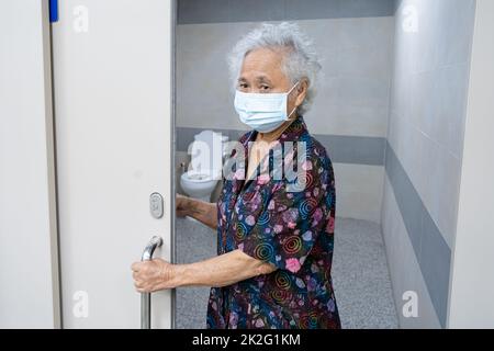 Asiatische ältere ältere alte Dame Frau Patient offene Toilette Bad von Hand in Krankenpflege-Station, gesund starke medizinische Konzept. Stockfoto