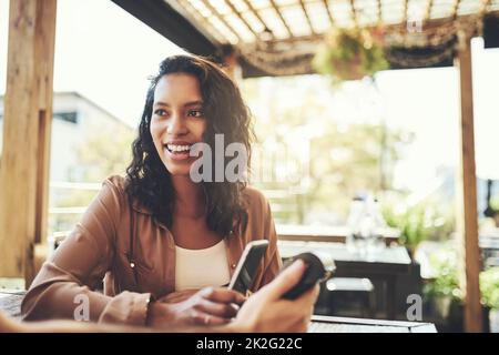 Lassen Sie Ihr Geld zu Hause, bezahlen Sie mit Ihrem Telefon. Aufnahme einer jungen Frau, die in einem Café eine drahtlose Zahlung macht. Stockfoto