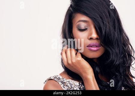 Verleihen Sie jedem Tag etwas Glamour. Studioaufnahme einer schönen jungen Frau, die vor einem hellen Hintergrund posiert. Stockfoto