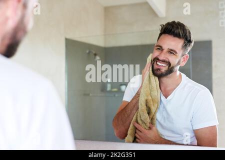 Sauberkeit ist neben Gottseligkeit. Die kurze Aufnahme eines hübschen jungen Mannes, der durchläuft, ist die morgendliche Routine im Badezimmer. Stockfoto