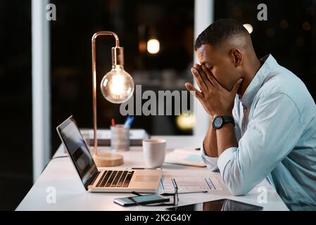 Ein Unternehmen zu führen, ist so viel Stress. Aufnahme eines hübschen jungen Geschäftsmannes, der sich gestresst fühlt, während er spät in seinem Büro arbeitet. Stockfoto