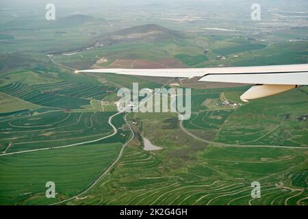 Hoch über dem Boden. Aus einem Flugzeugfenster eine Aufnahme aus dem hohen Winkel der Aussicht. Stockfoto