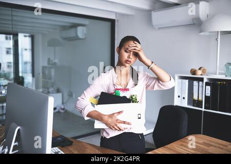 Es ist das stressigste, was einem passieren kann. Foto einer unglücklichen Geschäftsfrau, die ihre Kiste voller Sachen hält, nachdem sie von ihrem Job gefeuert wurde. Stockfoto