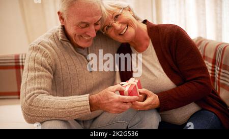 Dankbar für die Liebe zu Weihnachten. Aufnahme eines älteren Paares, das zu weihnachten Geschenke austauschte. Stockfoto