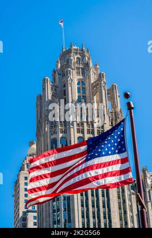 Winkende Flagge der USA mit Tribune Tower dahinter, Chicago, Illinois, USA Stockfoto