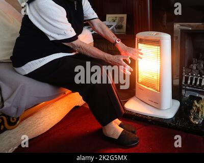 Aktenfoto vom 19/11/14 einer älteren Dame mit ihrem Elektrofeuer zu Hause. Räte und Sozialdienstleister fordern vor dem Minibudget erhebliche und sofortige Mittel, um einen „der schwierigsten Winter der letzten Zeit“ abzuwehren. Ausgabedatum: Freitag, 23. September 2022. Stockfoto