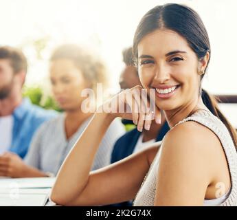 Wir halten unsere Zusammenarbeit gerne sehr lässig. Porträt einer jungen Geschäftsfrau, die sich im Freien mit ihren Kollegen trifft. Stockfoto