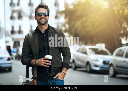 Dieses urbane Gefühl. Eine kurze Aufnahme eines hübschen jungen Mannes, der durch die Stadt reist. Stockfoto