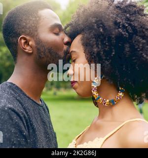 Wahre Liebe. Eine kurze Aufnahme eines liebevollen jungen Paares, das einige Zeit zusammen im Park verbringt. Stockfoto