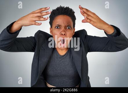 Was haben Sie gedacht? Porträt einer wütenden Geschäftsfrau, die vor grauem Hintergrund schreit. Stockfoto