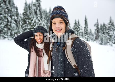 Liebhaber durch alle Jahreszeiten des Jahres. Aufnahme eines glücklichen jungen Paares, das sich beim draußen im Schnee amüsieren kann. Stockfoto