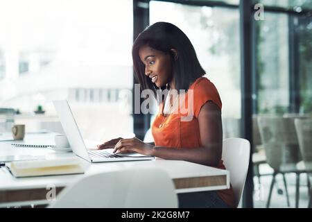 Shes war immer ein harter Arbeiter. Aufnahme einer attraktiven jungen Geschäftsfrau, die an ihrem Schreibtisch an einem Laptop arbeitet. Stockfoto