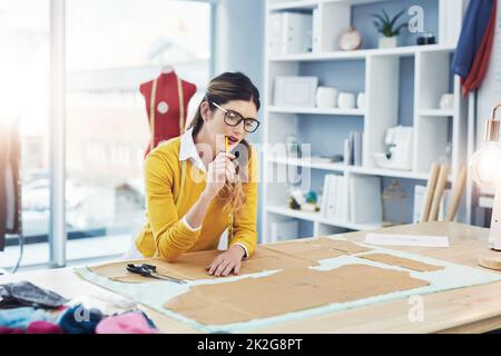 Vergessen Sie trendy, Shell machen Sie zu einem Klassiker. Eine kurze Aufnahme einer attraktiven jungen Modedesignerin in ihrer Werkstatt. Stockfoto