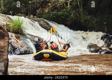 Gehen Sie dorthin, wo Sie sich am lebendigsten fühlen. Aufnahme einer Gruppe von Freunden beim Rafting an einem sonnigen Tag. Stockfoto