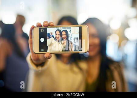 Ich habe mich einfach nur mit meinem Lieblingsmenschen abgesetzt. Zugeschnittene Aufnahme von zwei jungen Freunden, die zusammen ein Selfie machen. Stockfoto