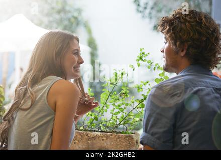 Er lässt mein Herz schmelzen Ausgeschnittene Aufnahme eines jungen Paares, das sich im Sitzen unterhielt. Stockfoto