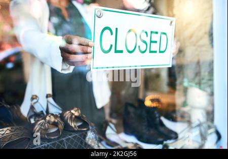 Bis morgen. Ausgeschnittene Aufnahme einer nicht erkennbaren Frau, die ein geschlossenes Schild hochhält. Stockfoto