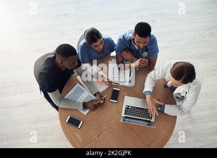 Der beste Arzt ist der, zu dem Sie laufen und den Sie nicht finden können. Schoss eine Gruppe von Ärzten, die im Büro bei der Arbeit über Arbeitsangelegenheiten diskutierten. Stockfoto