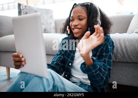 Technologie hält mich mit allen meinen Freunden in Verbindung. Aufnahme eines jungen Mädchens mit einem digitalen Tablet zu Hause. Stockfoto