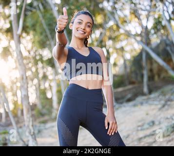 Tun Sie es für die Endorphine. Porträt einer jungen Frau, die beim Arbeiten in der Natur Daumen nach oben zeigt. Stockfoto