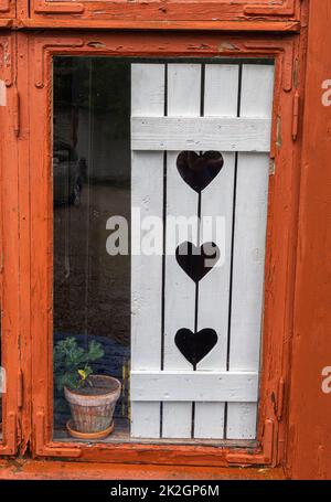 Traditioneller weißer Fensterverschluss mit Herzform Stockfoto