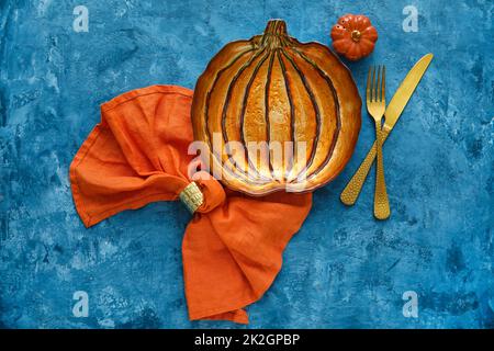 Herbstliche Tischeinstellung mit Kürbisplatte auf grungenem Hintergrund Stockfoto