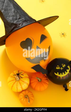 Komposition mit Halloween-Ballons und Kürbissen auf farbigem Hintergrund, Nahaufnahme Stockfoto