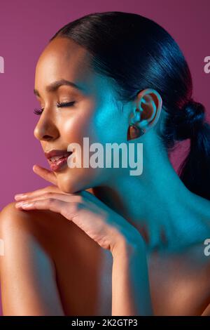 Perfekte Profilierung. Beschnittene Aufnahme einer attraktiven jungen Frau, die im Studio vor einem rosa Hintergrund posiert. Stockfoto