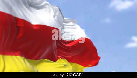 Detail der Nationalflagge Südossetiens, die an einem klaren Tag im Wind winkt. Stockfoto