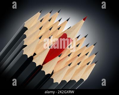 Roter Bleistift, der zwischen schwarzen Bleistiften steht Stockfoto