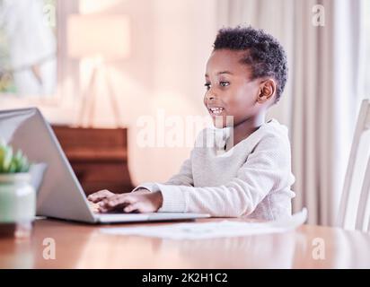 Der Bildung ist kein Ende gesetzt. Aufnahme eines Jungen, der zu Hause seine Hausaufgaben auf einem Laptop macht. Stockfoto