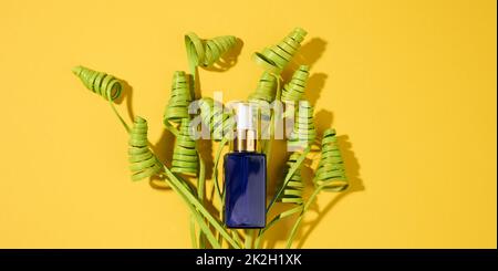 Blaue Glasflaschen mit Pipette auf gelbem Hintergrund. Kosmetik SPA Branding Mockup, Draufsicht Stockfoto