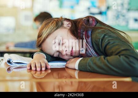 Shes erfrischt ihren jungen Geist. Aufnahme einer entzückenden Grundschülerin, die in der Klasse ein Nickerchen auf ihrem Schreibtisch macht. Stockfoto