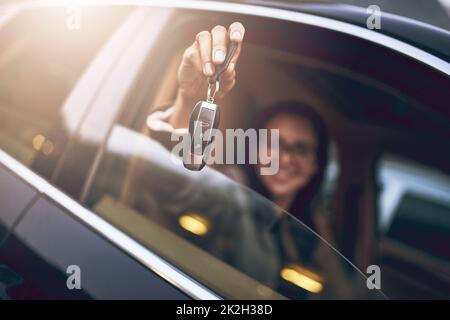 Raten Sie mal, wer gerade ein paar neue Räder gekauft hat. Porträt einer Geschäftsfrau, die die Schlüssel für ihr neues Auto hält. Stockfoto