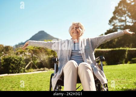 Nehmen Sie sich ihre Freiheit nicht weg. Aufnahme einer älteren Frau, die im Freien sitzt, während sie in ihrem Rollstuhl sitzt. Stockfoto